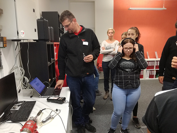 Schülerin testet Motor auf Schäden